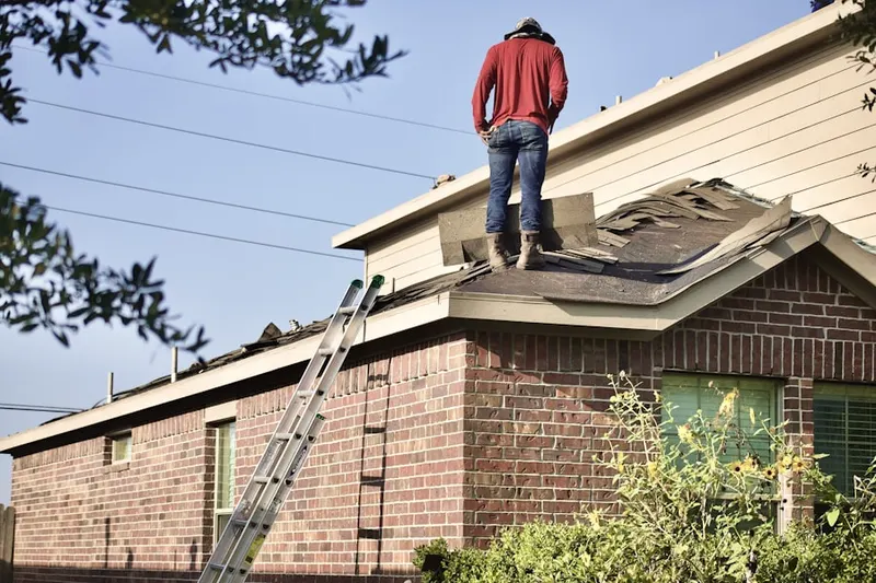 Professional roofer working on a residential roof in Osage